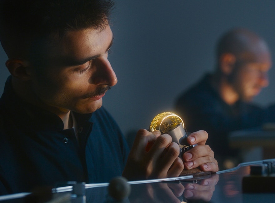 A man in a workshop working on a bracelet